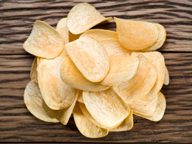 Tahta arka planda patates cipsi..