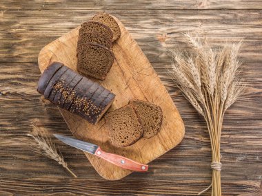 Siyah ekmek üzerinde ahşap tahta dilimlenmiş.