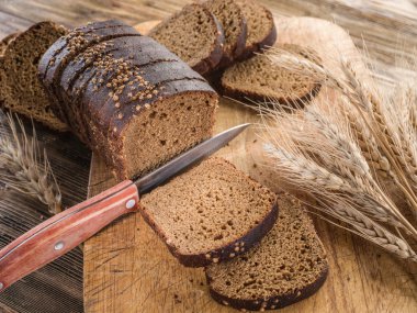 Siyah ekmek üzerinde ahşap tahta dilimlenmiş.