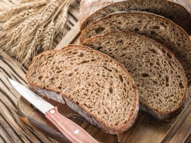 Siyah ekmek üzerinde ahşap tahta dilimlenmiş.