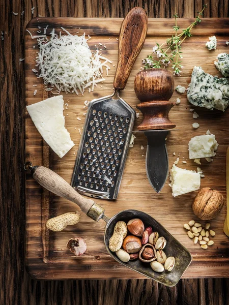 Different types of cheeses with nuts and herbs. — Stock Photo, Image