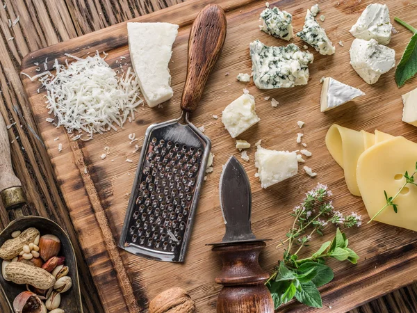 Verschillende soorten kaas met noten en kruiden. — Stockfoto