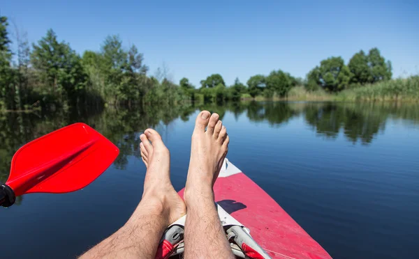 Man's legs over canoe. Resting time. — Stock Photo, Image