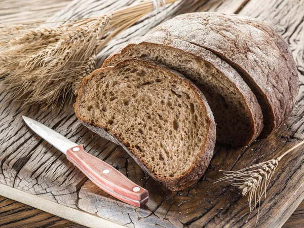 Zwart brood gesneden op de houten plank. — Stockfoto