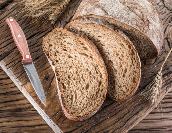 Zwart brood gesneden op de houten plank. — Stockfoto