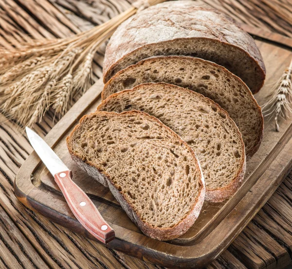 나무 판자에 검은 빵을 슬라이스. — 스톡 사진