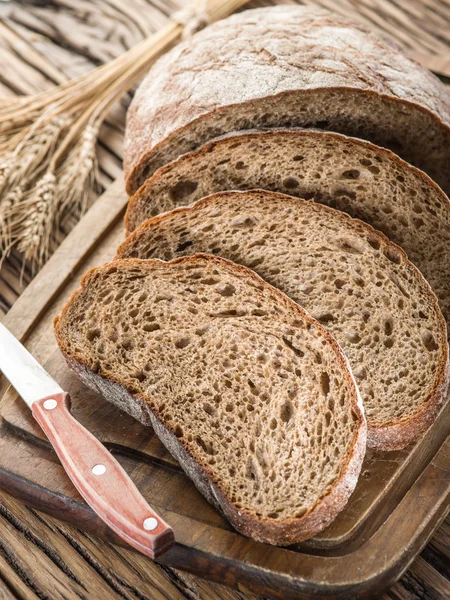 Pane nero affettato sulla tavola di legno . — Foto Stock