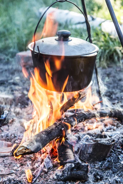 Cuisinière sous le feu de joie dans la forêt . — Photo