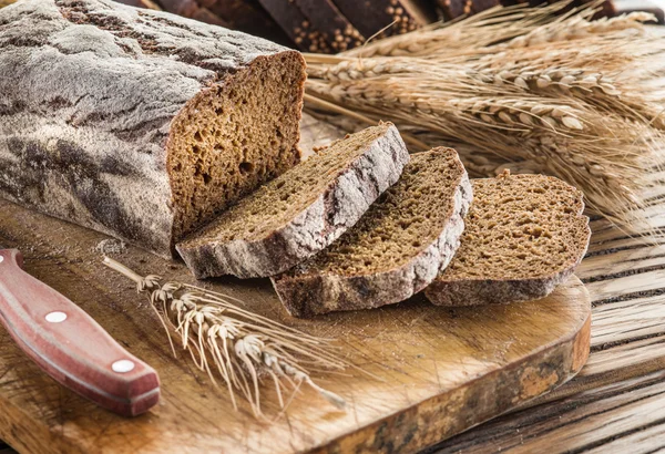 Zwart brood gesneden op de houten plank. — Stockfoto