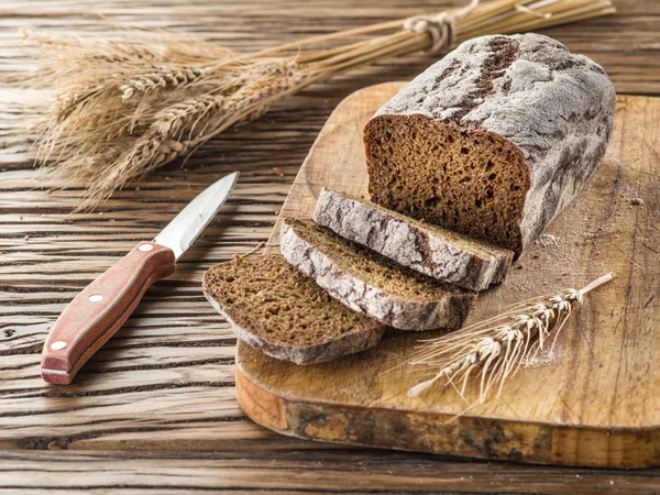 Sliced black bread on the wooden plank. — Stock Photo, Image