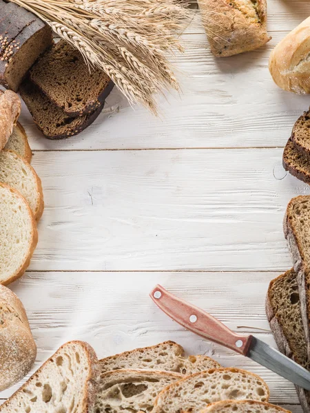 The bread and a wheat on the wooden desk. — Stock Photo, Image