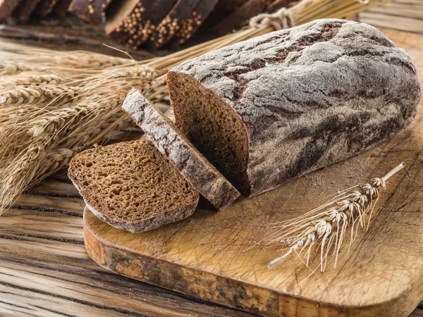 Zwart brood gesneden op de houten plank. — Stockfoto