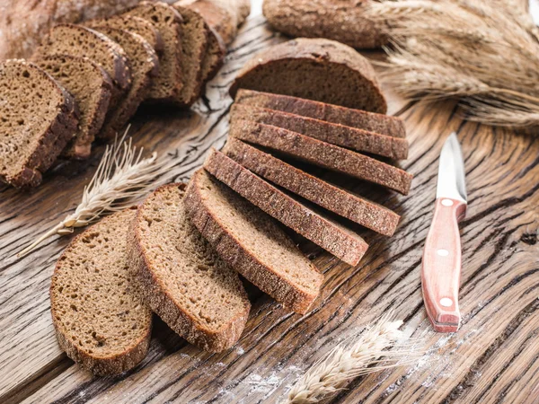 Zwart brood gesneden op de houten plank. — Stockfoto