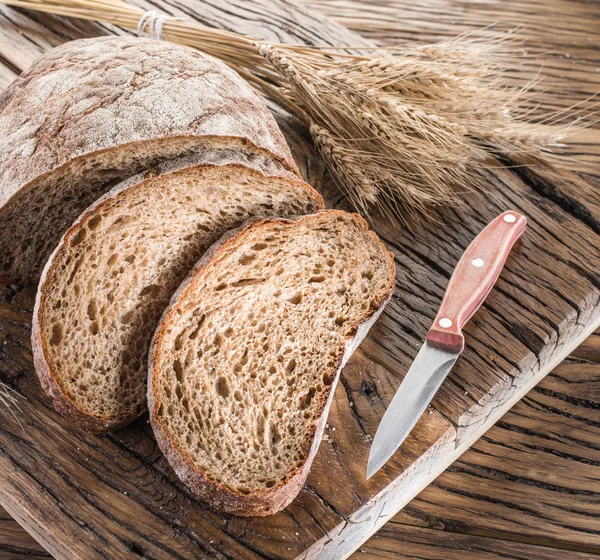 Zwart brood gesneden op de houten plank. — Stockfoto