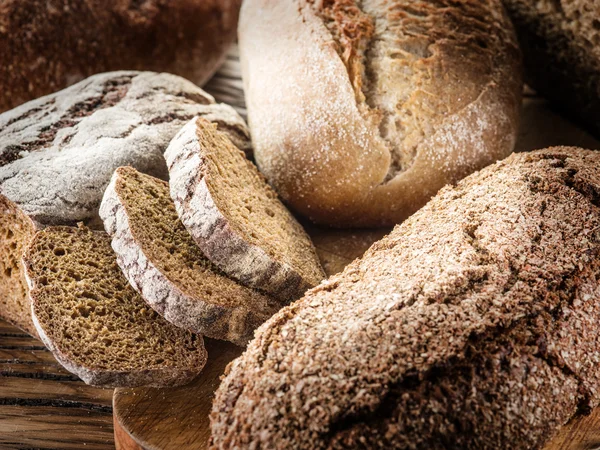 Svart bröd limpor på en planka. — Stockfoto