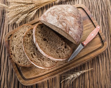 Siyah ekmek üzerinde ahşap tahta dilimlenmiş.