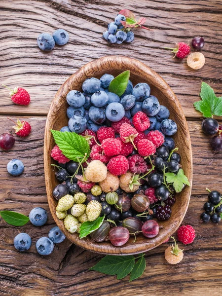 Ripe berries in the wooden bowl. — Stock Photo, Image