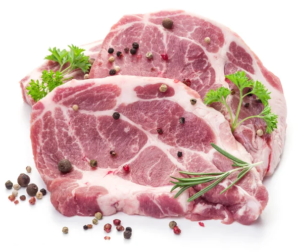Ruwe varkensvlees vlees steaks met specerijen op de witte achtergrond. — Stockfoto