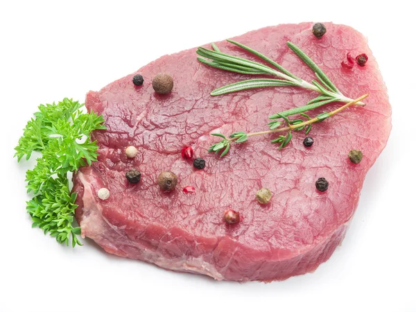 Rå nötkött biffar med kryddor på en vit bakgrund. — Stockfoto