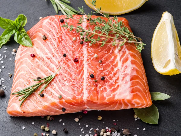 Salmón fresco en la tabla de cortar negra . — Foto de Stock