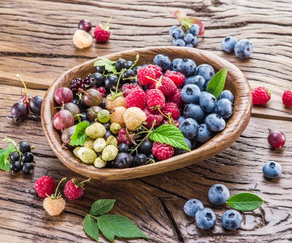 Ripe berries in the wooden bowl. — Stock Photo, Image