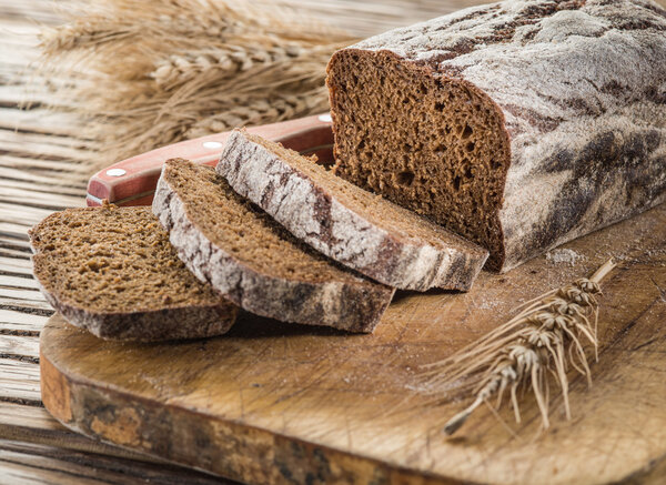 Sliced black bread on the wooden plank.