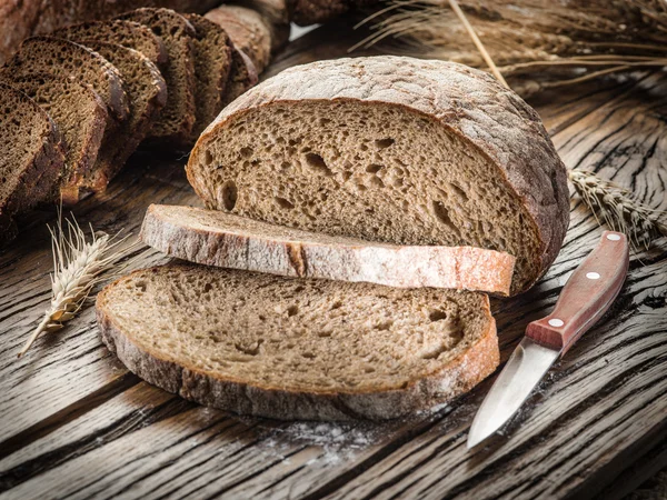 Zwart brood gesneden op de houten plank. — Stockfoto