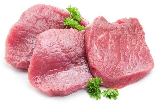 Raw beaf steaks with parsley on a white background.