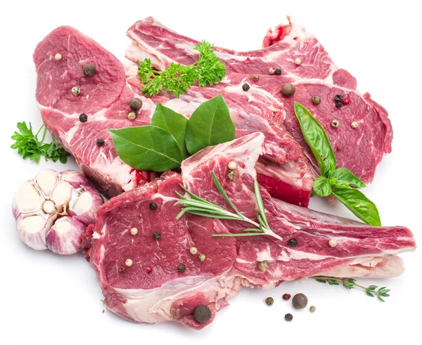 Carne di maiale cruda bistecche con spezie sullo sfondo bianco . — Foto Stock