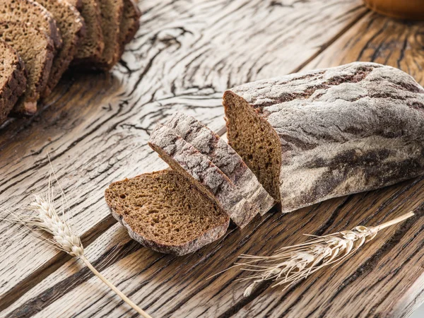 Zwart brood gesneden op de houten plank. — Stockfoto