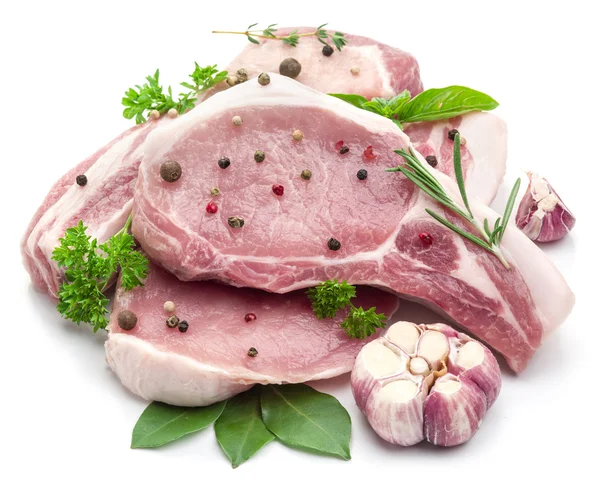 Ruwe varkensvlees vlees steaks met specerijen op de witte achtergrond. — Stockfoto