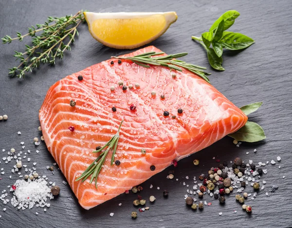 Fresh salmon on the black cutting board. — Stock Photo, Image