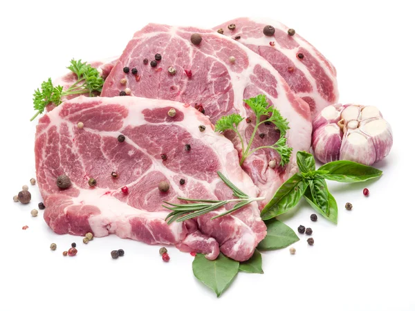 Ruwe varkensvlees vlees steaks met specerijen op de witte achtergrond. — Stockfoto