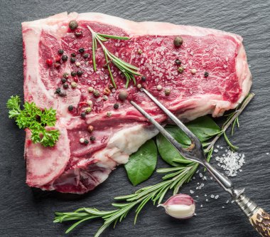 Baharat siyah kesme tahtası üzerinde ham sığır eti biftek.