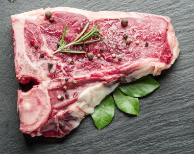 Baharat siyah kesme tahtası üzerinde ham sığır eti biftek.