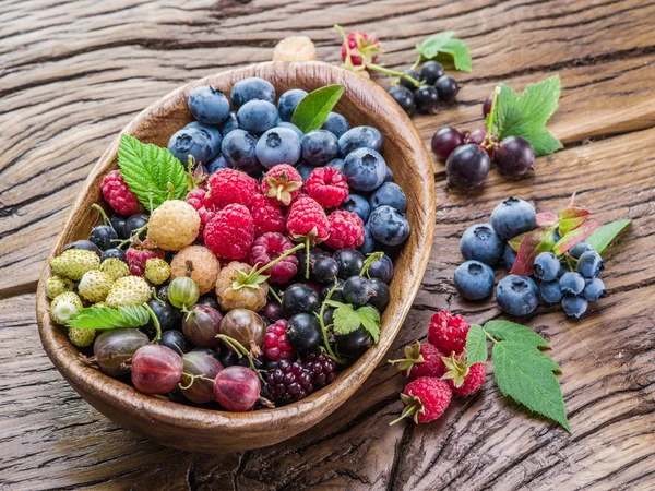 Ripe berries in the wooden bowl. — Stock Photo, Image