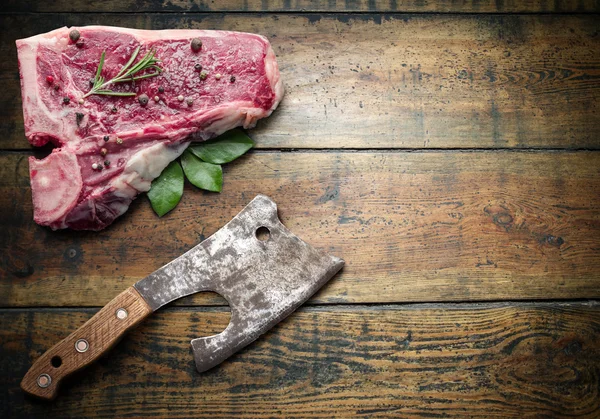 Steak de bœuf cru aux épices sur une planche de bois . — Photo