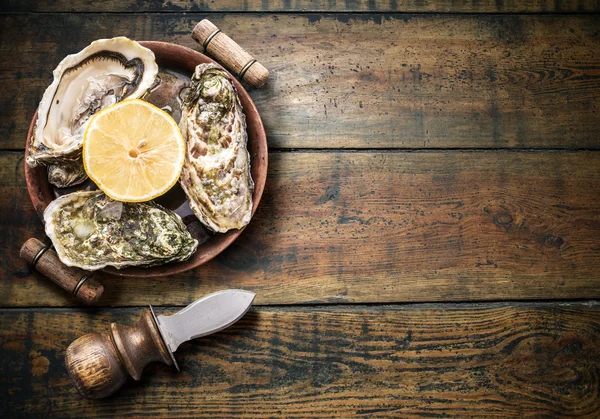 Raw oysters on the old wooden table. — Stock Photo, Image