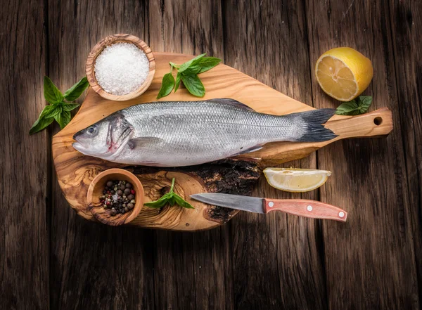 Seabass fish on the graphite board. — Stock Photo, Image