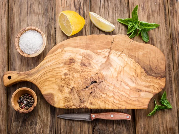 Olive snijplank en specerijen op een houten tafel. — Stockfoto