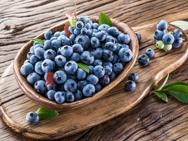 Bleuets mûrs dans le bol sur la table en bois . — Photo