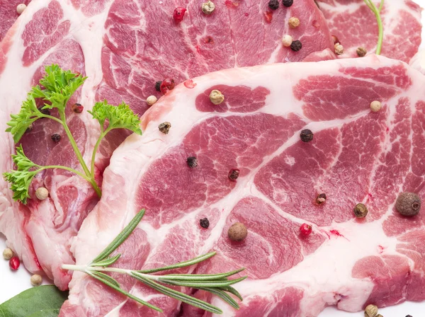 Raw pork meat steaks with spices on the white background. — Stock Photo, Image