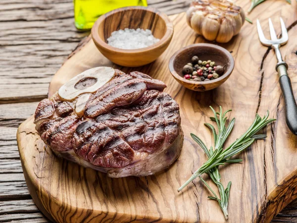 Rindersteaks mit Gewürzen auf einem Holztablett. — Stockfoto