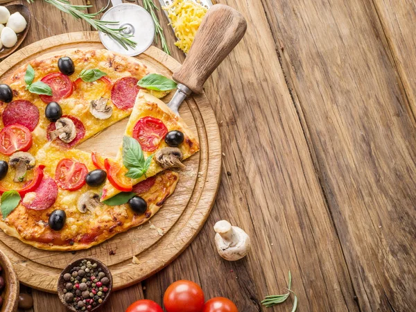 Mantar, salam ve domates pizza.