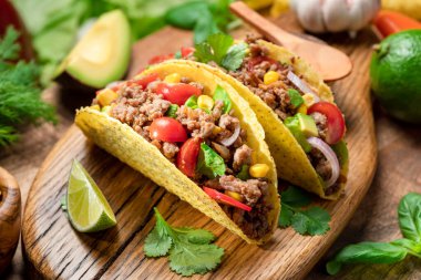 Tahta servis tahtasının yanında Meksika usulü et, tortilla ve limon dilimleri.. 