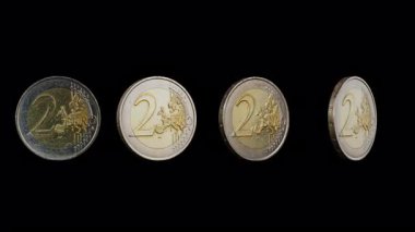  İki avroluk sikkelerin çoğu siyah arkaplanda kendi ekseni etrafında dönüyor.