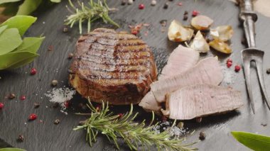 Gri servis taşında ızgara pirzola bifteği deniz tuzu ile tuzlanır..