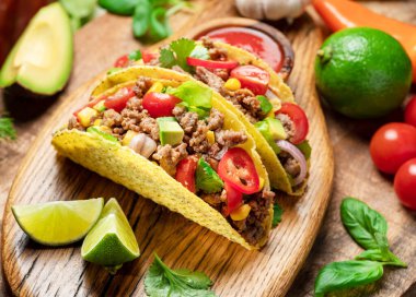 Tahta servis tahtasının yanında Meksika usulü et, tortilla ve limon dilimleri.. 