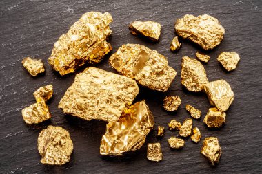 Altın külçeleri siyah taştan arka planda üst manzarada. Altın külçelerinin taklidi.