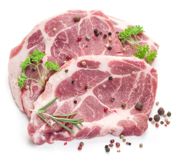 Ruwe varkensvlees vlees steaks met specerijen op de witte achtergrond. — Stockfoto